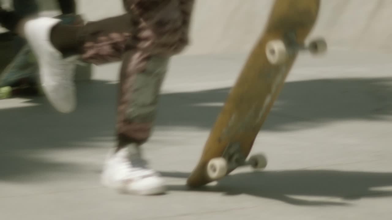 카모 바지를 입은 스케이트보더가 달리고 보드를 떨어뜨리고, 타기 위해 뛰어든다.