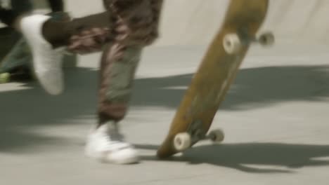 skateboarder in camo pants running and dropping board, jumps on to ride