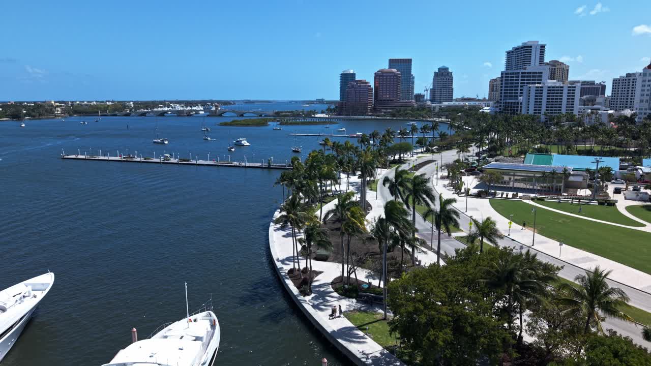 Aerial: downtown West Palm Beach cityscape with Atlantic Ocean and palm trees during the day in Florida, USA, push in drone shot