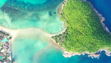 Heart-shape-tropical-island-with-green-lush-vegetation-and-rocks-on-seashore-washed-by-blue-turquoise-sea-in-Thailand