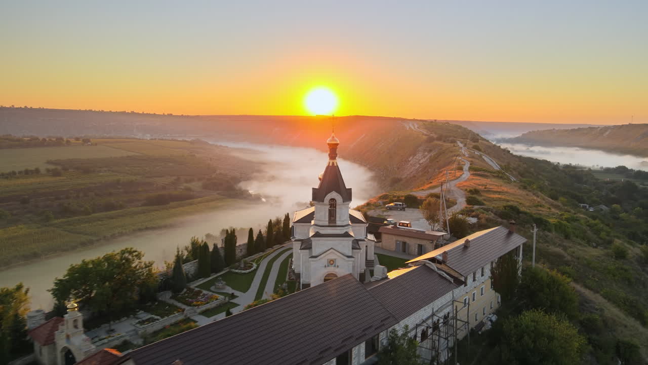 Aerial drone view of the Old Orhei at sunset. Valley with river and fog, monastery located on a hill in Moldova