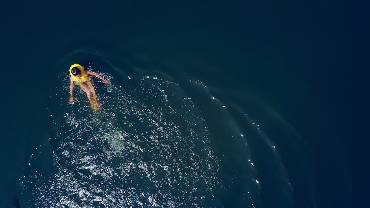The guy is swimming in the river. Happy children on summer vacation. Aerial view