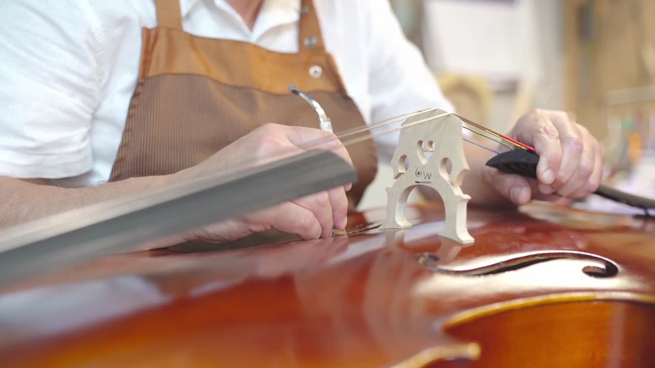 Liutaio che installa l'anima al violino