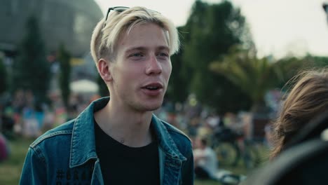 group of young caucasian friends chatting and  having fun on music festival.