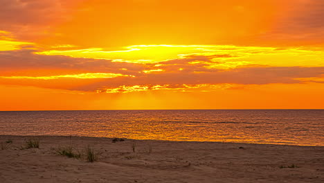 majestic seaside yellow and orange sunset in the beach with clouds, timelapse