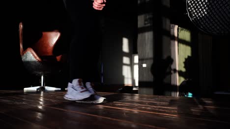 filmmaker perform smooth ninja walk on wooden indoor studio floor