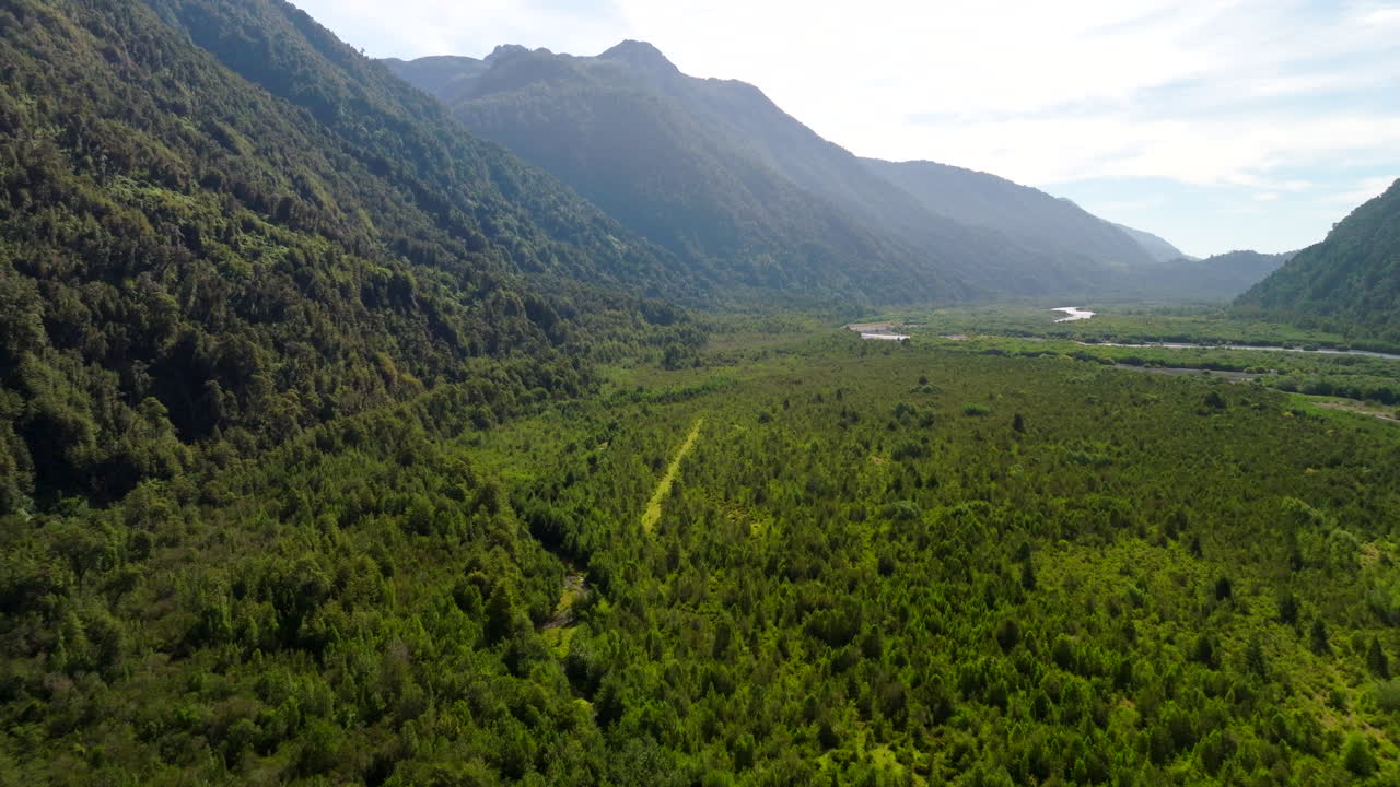 Aerial footage of the Petrohué River winding through lush Patagonian forests and volcanic terrain in Chile’s Vicente Pérez Rosales National Park under soft, natural light