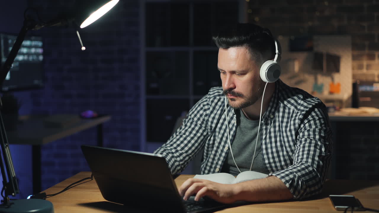 Homem a trabalhar tarde da noite no portátil