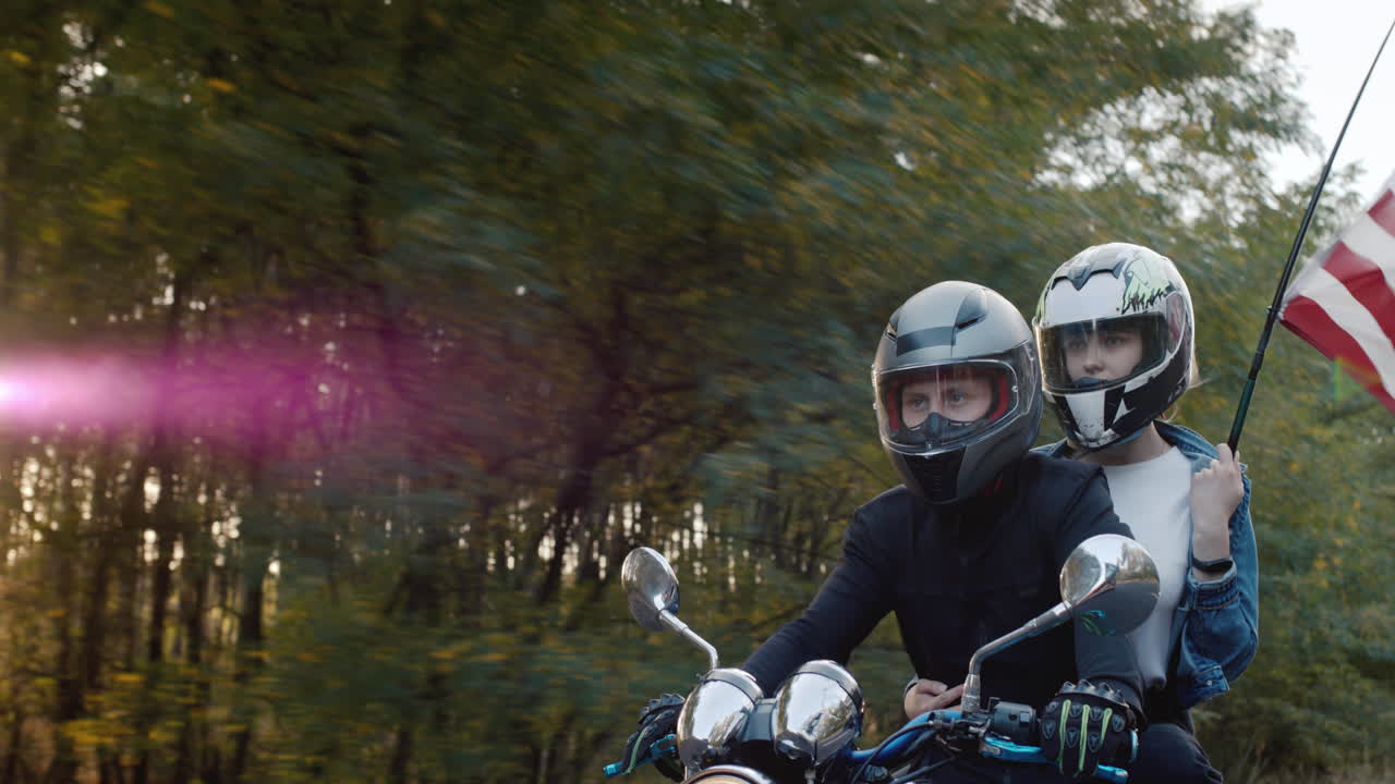 여자 친구와 함께 젊은 바이커는 태양 1에서 오토바이를 탄다