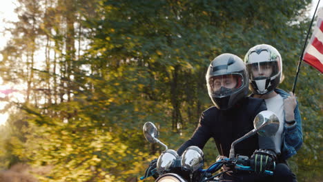 young biker with girlfriend rides a motorcycle in the sun 1