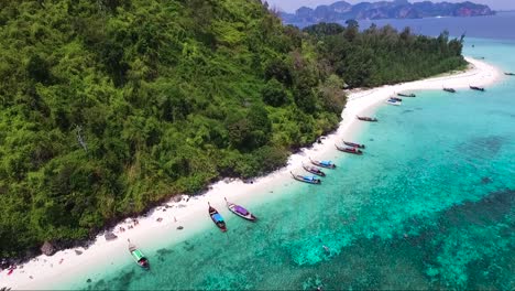 excelente toma aérea sobre una hermosa isla tropical con botes alineados en la orilla