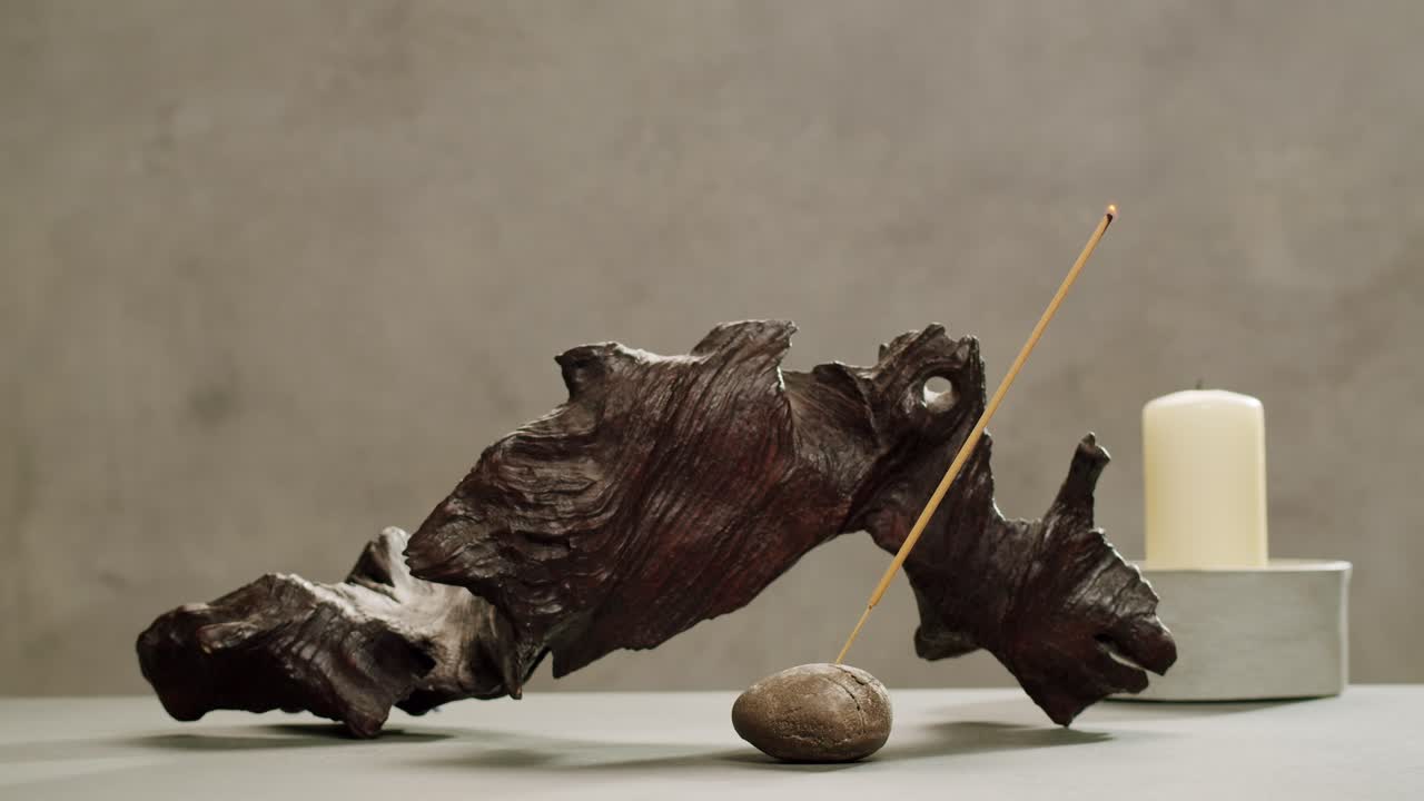 Person holding Palo Santo wood stick in hand, aromatic Palo Santo burning on black background, smoke spreading around, slow motion video clip, high quality 4k close up footage. High quality 4k footage