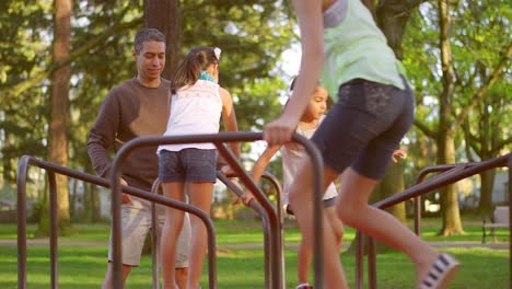 father pushing his daughters on a merry-go-round