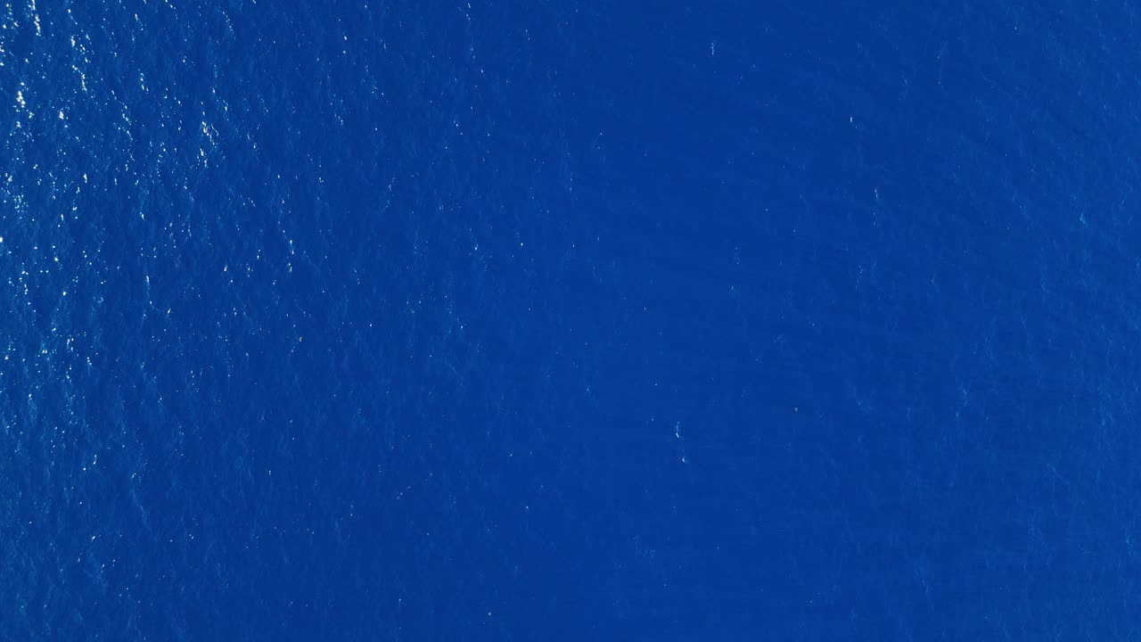 Serene aerial of endless blue ocean with gentle waves, perfect for peaceful and soothing backdrops, top down static