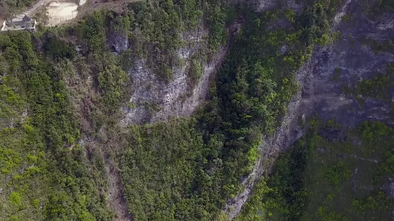 atrevida vista aérea vuelo lentamente inclinado hacia abajo drone vuelo de peligro intacto naturaleza playa kelingking en nusa penida bali indonesia parque jurásico