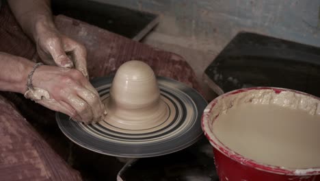 the potter makes a jug of clay. ceramist. a man makes a vase on a potter's wheel