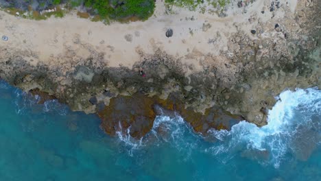 Couple-sitting-on-the-rocky-sea-coast-4k