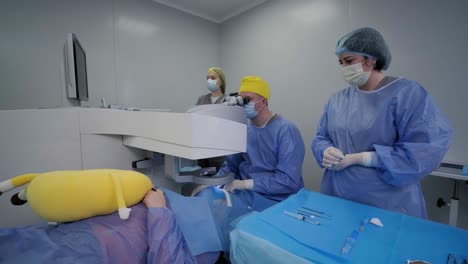 corrección de la visión con láser. un paciente y un equipo de cirujanos en la sala de operaciones durante una cirugía oftalmológica
