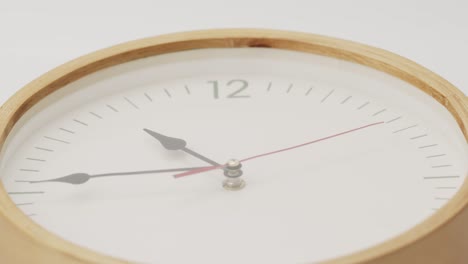 white wall clock tells the time 12 o'clock.