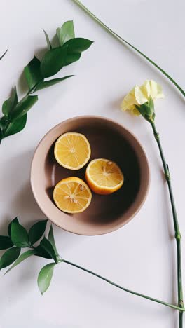 lemons in a bowl with flowers and leaves