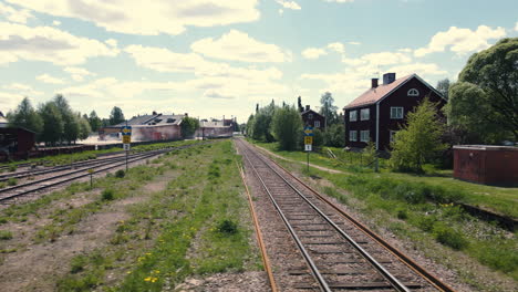 Railroad-in-industrial-area-with-cars-driving-past-in-background