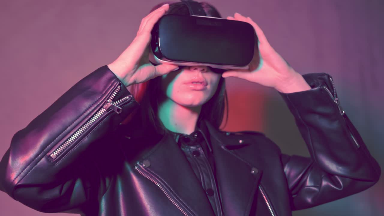Young beautiful woman in a leather jacket putting virtual reality head set on her eyes