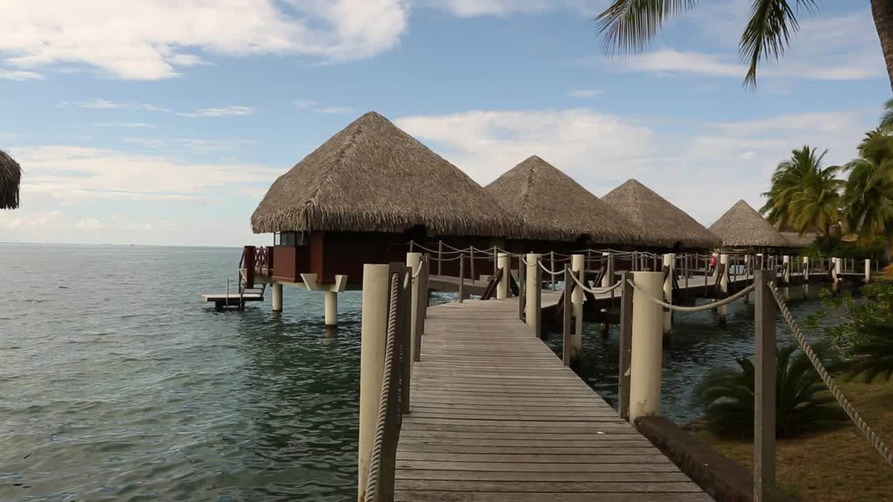 encantadoras cabañas turísticas tahitianas en el mar con un puente de madera para ellas