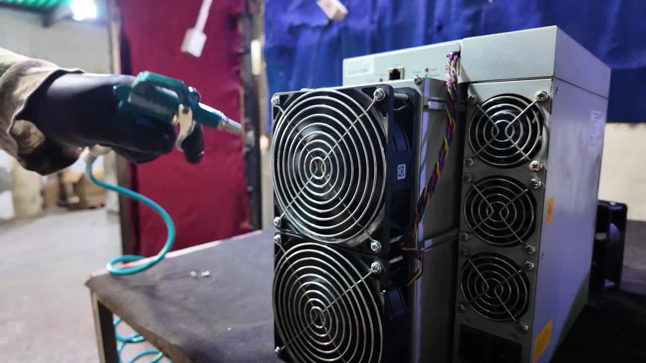 Cryptocurrency mining machine with visible cooling fans and internal components. Blockchain infrastructure, digital currency technology, data processing, and professional hardware repair