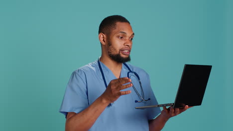 Hospital-staff-member-listening-to-patient-in-videocall-using-laptop