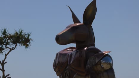 metal kangaroo sculpture with tree and sky background