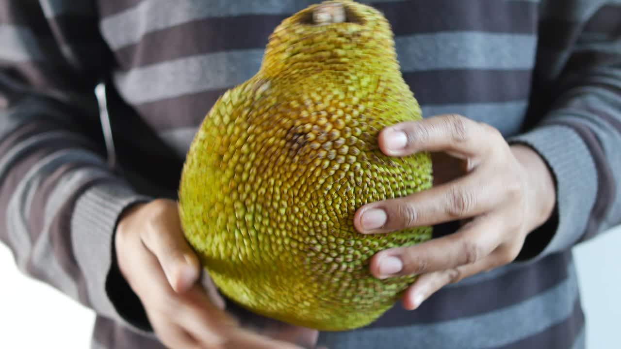 persona que sostiene una jackfruit
