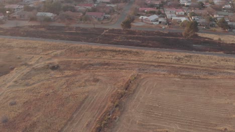 AERIAL-over-a-field-with-a-train-track-during-winter-time