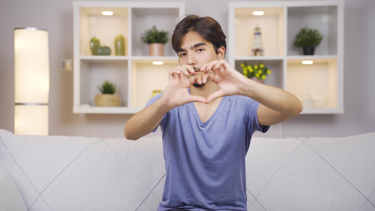 남자가 카메라에 심장 표시를 하고 있습니다.