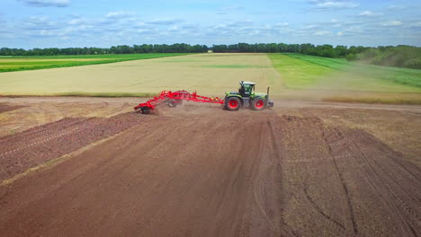 Farming-tractor-with-trailer-plowing-agricultural-field.-Rural-economy