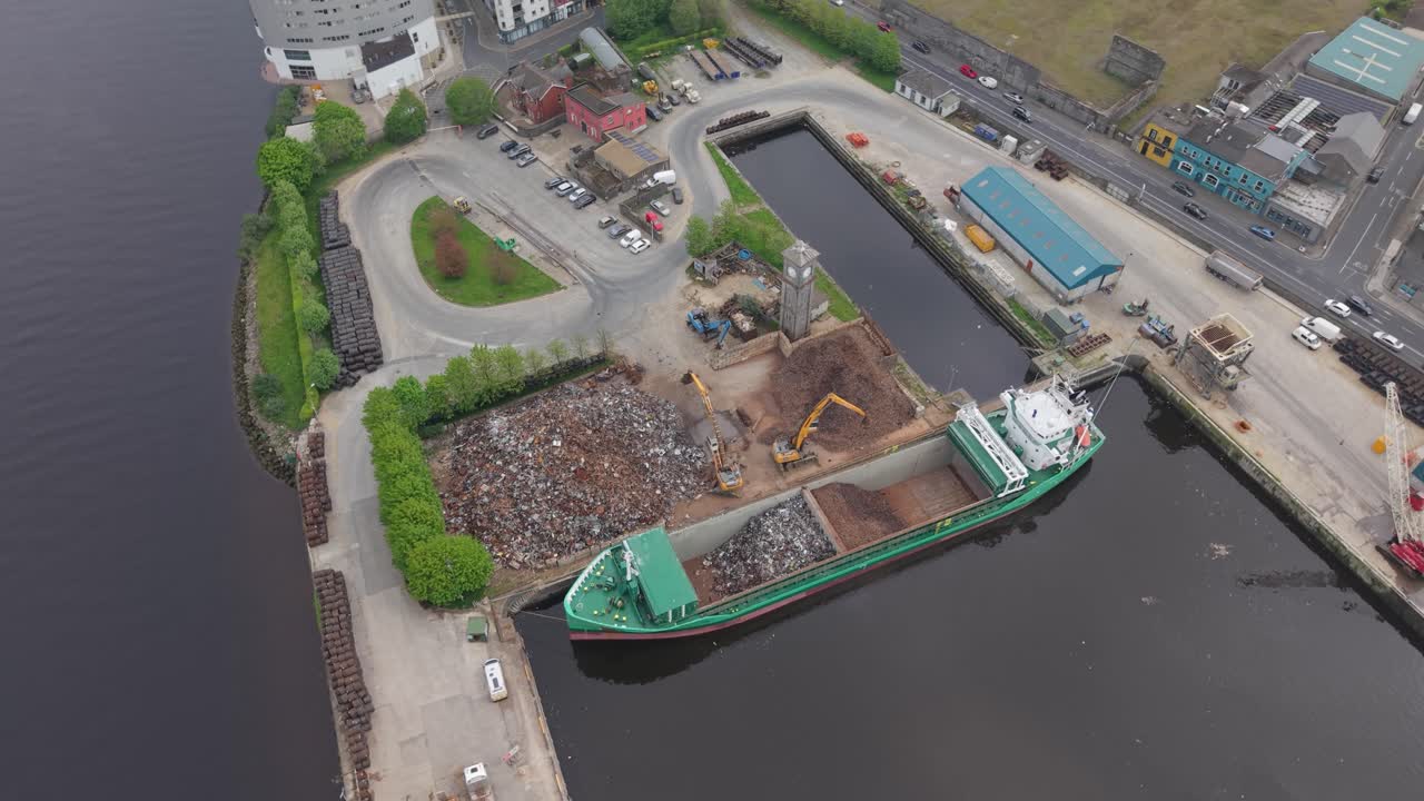 Loading scrap metal and wood onto a ship at a port in Limerick city, Ireland