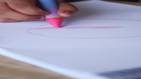 child drawing a circle with crayon