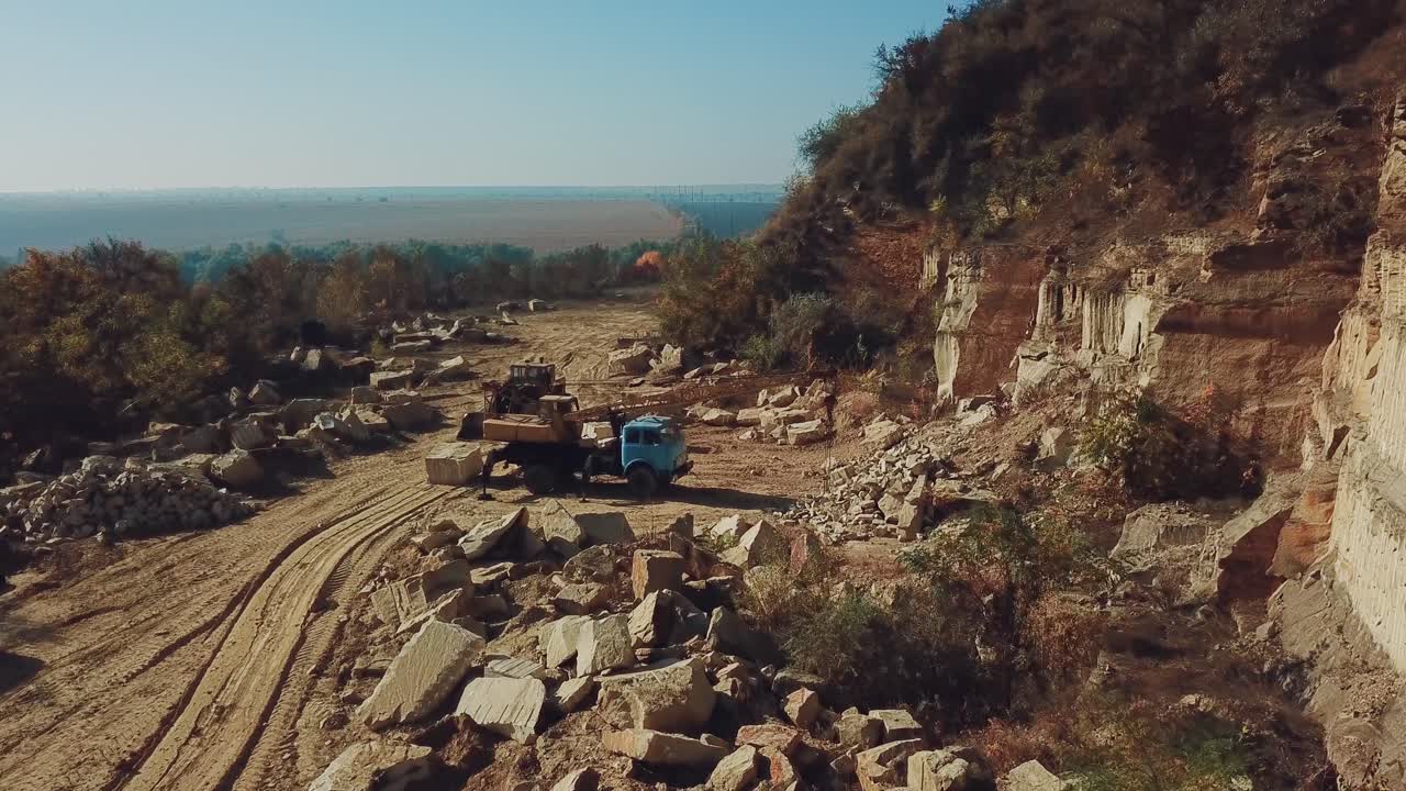 Specially equipped machinery mines and moves stones from the quarry for further processing in production. Aerial view.