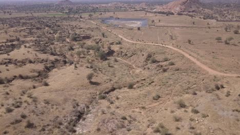 drone flying over the broad barren lands in rajasthan, india on a sunny day - aerial