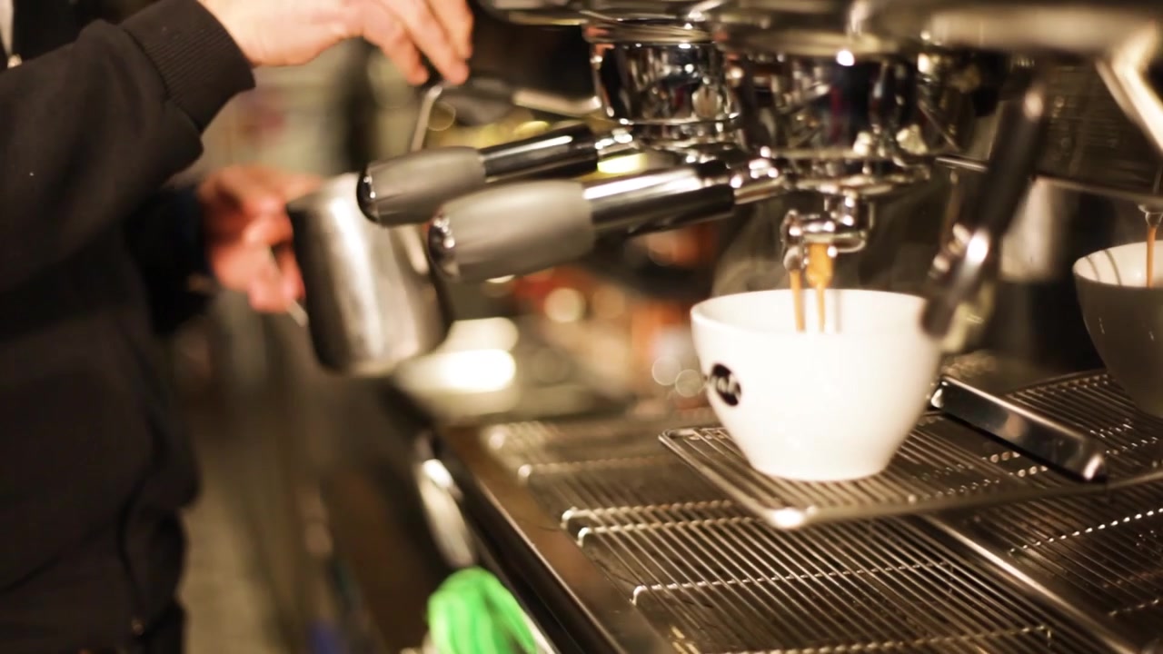Barista is making a cup of coffee.