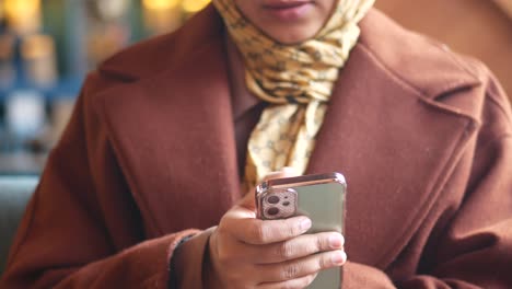 mujer usando el teléfono en un café