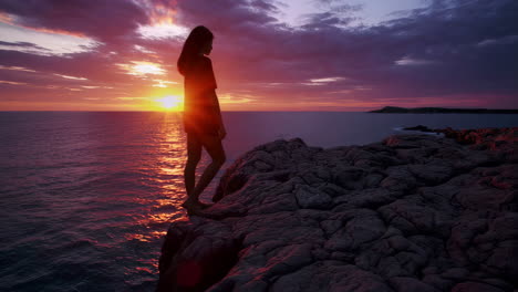 woman watching sunset from a cliff
