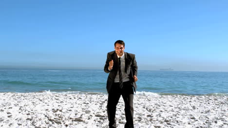 hombre de negocios libre bailando en la playa