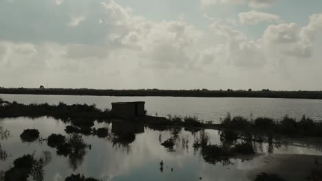 aerial silhouette view lonely hut on lakeside in rural landscape in pakistan