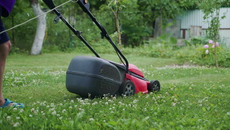 little boy running with a lawn mower in the garden