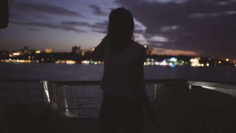 silhouette of a young happy girl feeling awesome and dance on the ship at dark night