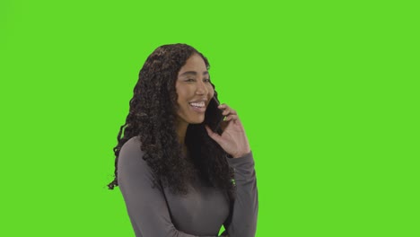 frustrated woman talking on mobile phone against green screen before hanging up