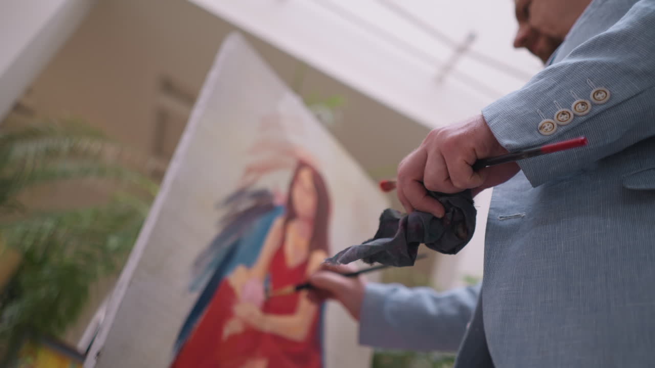 예술가는 여성의 초상화를 능숙하게 그립니다. 재능있는 남자는 화려한 솔 스트로크로 시각적 내러티브를 향상시니다. 초상화는 스튜디오에서 모양을 니다.