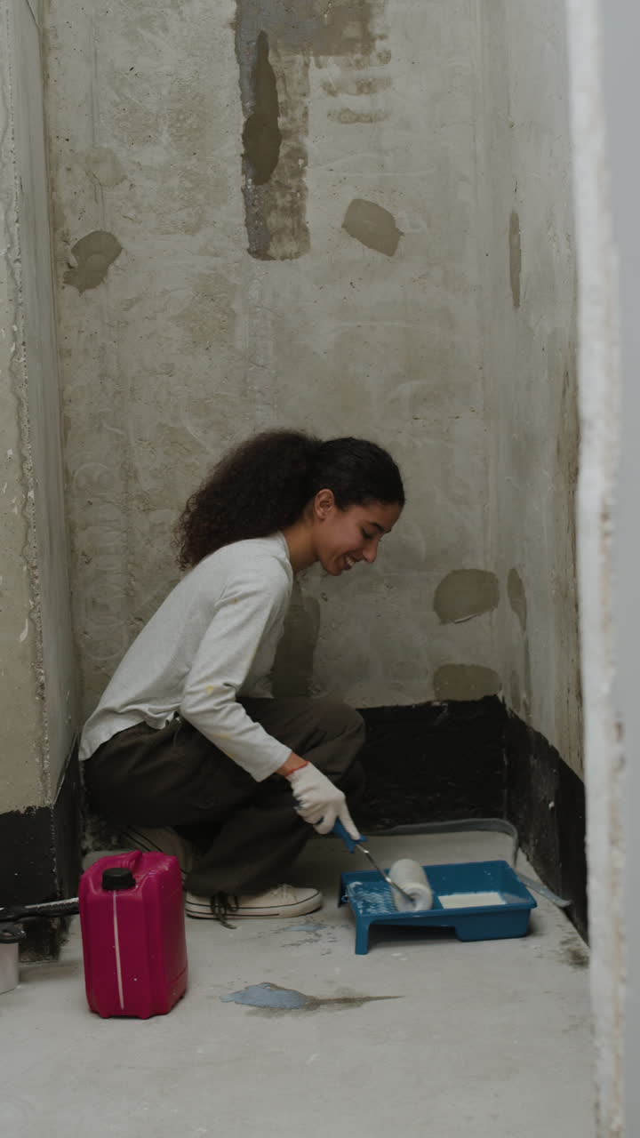 Young Woman Painting a Wall During Home Renovation