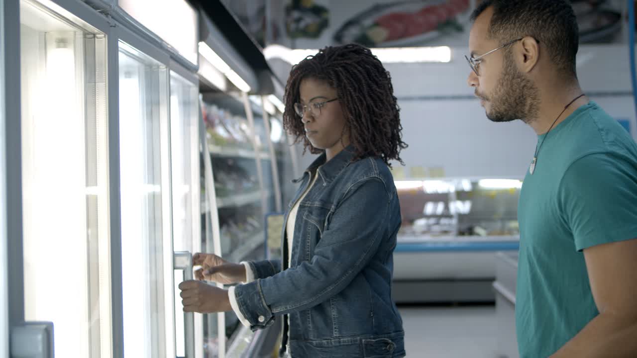 Coppia afroamericana sorridente che fa la spesa al supermercato