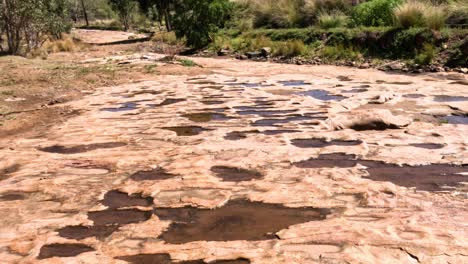 el agua se extiende gradualmente sobre la superficie de arenisca erosionada